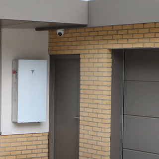 Solar panel mounted on a brick wall next to a window